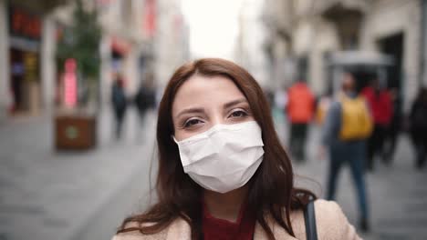 beautiful girl wearing protective medical mask and fashionable clothes smiles at street