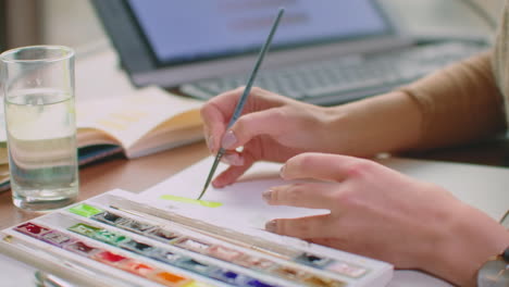 mujer joven con pincel y pintura haciendo coincidencia de colores crear paleta de colores para la coincidencia de color para el diseño