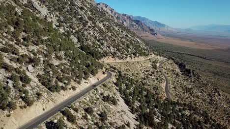 Sierra-Nevada-Mountain-Range-Hillside-Road-and-Moving-Car,-Aerial-View-With-Alabama-Hills-in-Background-USA