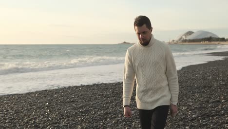 man walking on a pebble beach