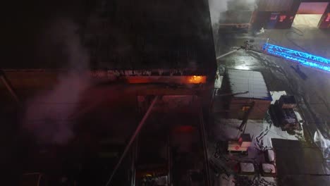 burning industrial building with smoke rising and emergency lights, ste-catherine, quebec, canada.