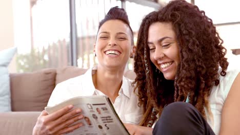 una pareja feliz de lesbianas leyendo una revista