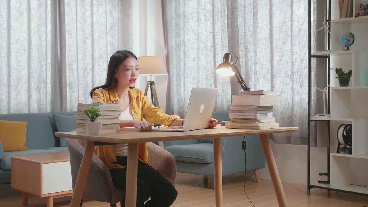 노트북과 책으로 집에서 공부하는 여자