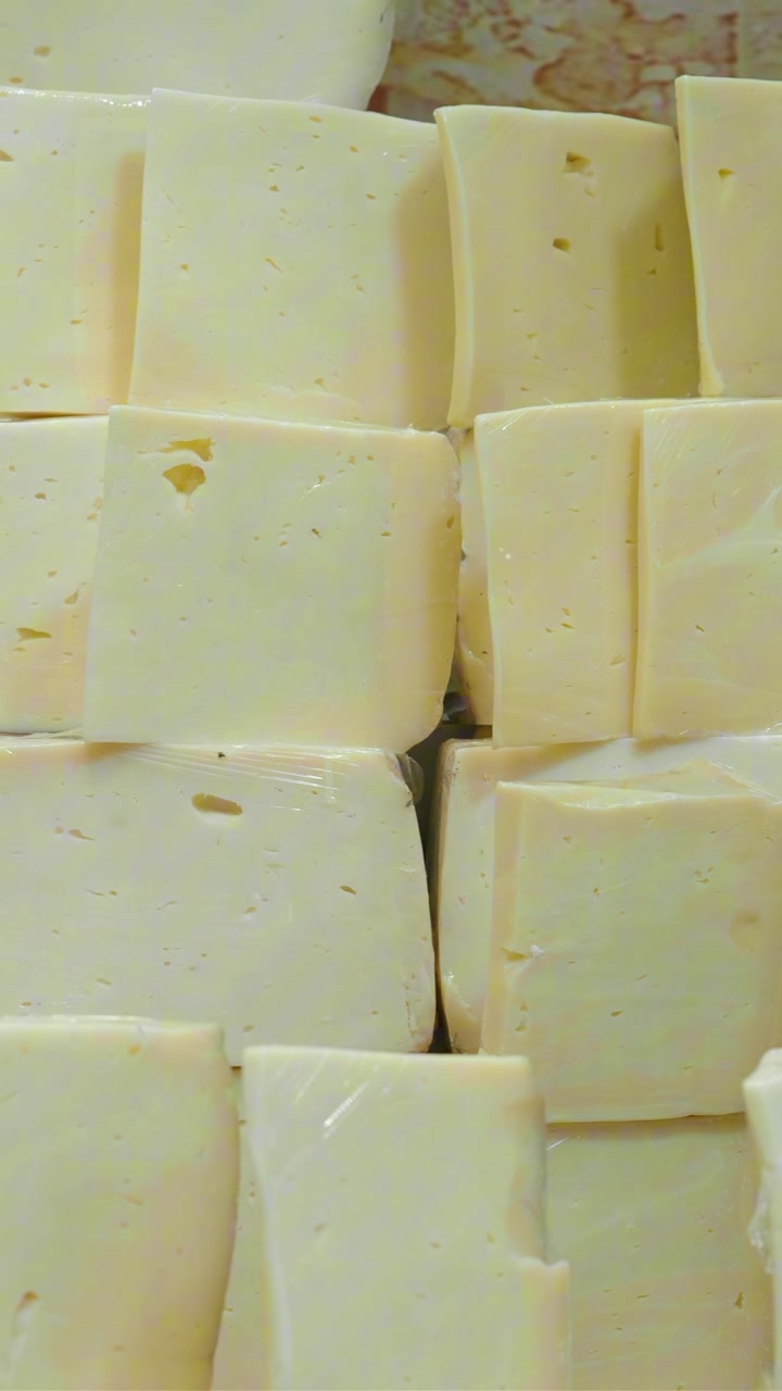 Stacked Blocks of Fresh Yellow Cheese in a Display