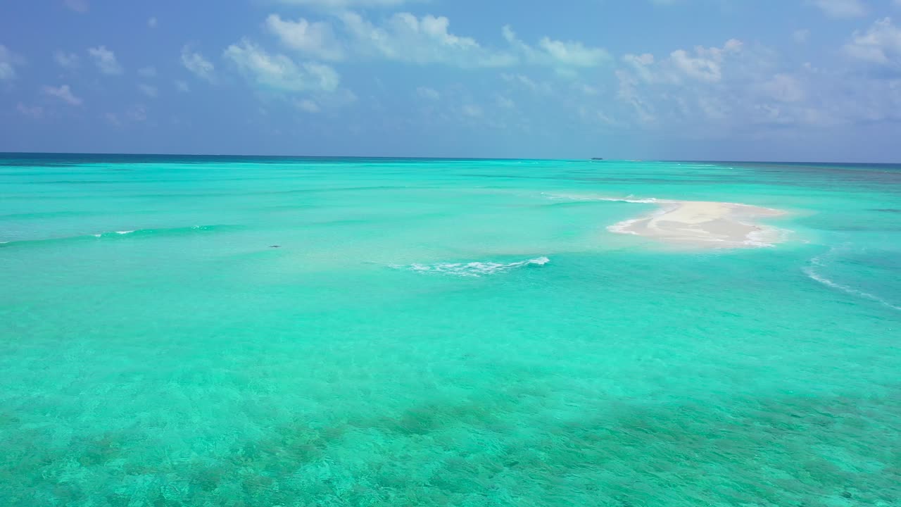 paisaje paradisíaco de aguas claras y tranquilas en color turquesa alrededor de una pequeña pila de arena blanca bajo un cielo nublado brillante en maldivas