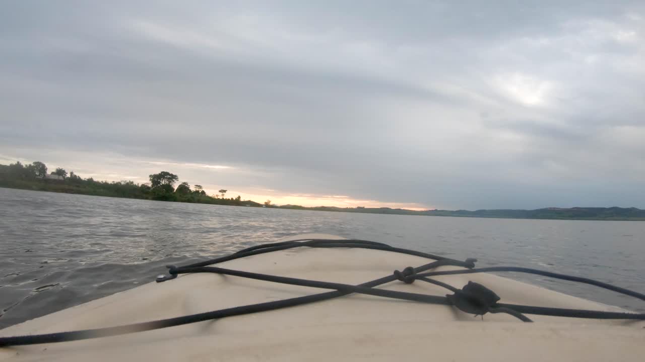 수평선에 떠오르는 태양과 함께 빅토리아 호수 아프리카에서 카약 코의 아래로 낮은 관점 샷