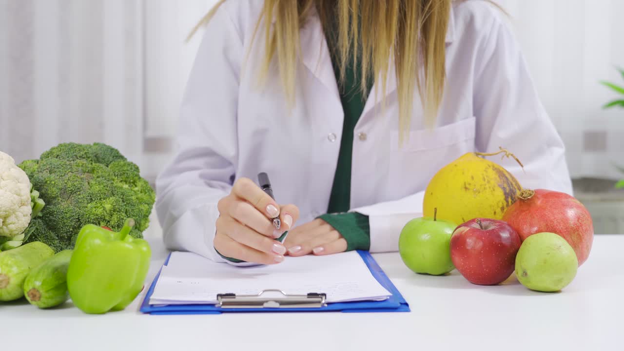 el dietista escribe una lista de dieta de verduras y frutas saludables.