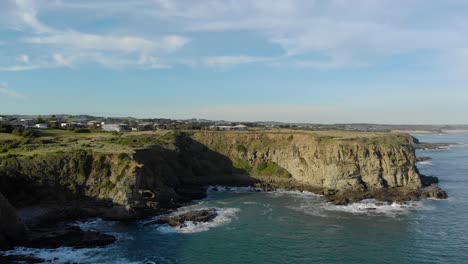 Aerial-shot-of-a-coastal-community-and-houses-on-top-of-a-cliff-in-southern-Australia