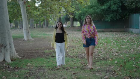 dos mujeres caminando en un parque