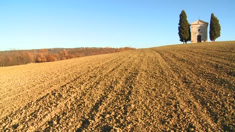 un tiro a través de los campos de toscana italia a una iglesia antigua