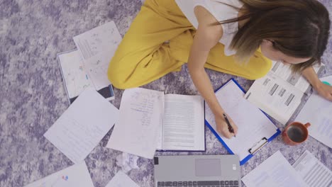 el lapso de tiempo de la mujer ocupada y los documentos de papel en el suelo.