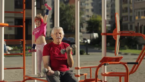 nieta y abuelo haciendo ejercicios de fitness con pesas. hombre mayor con niño niña