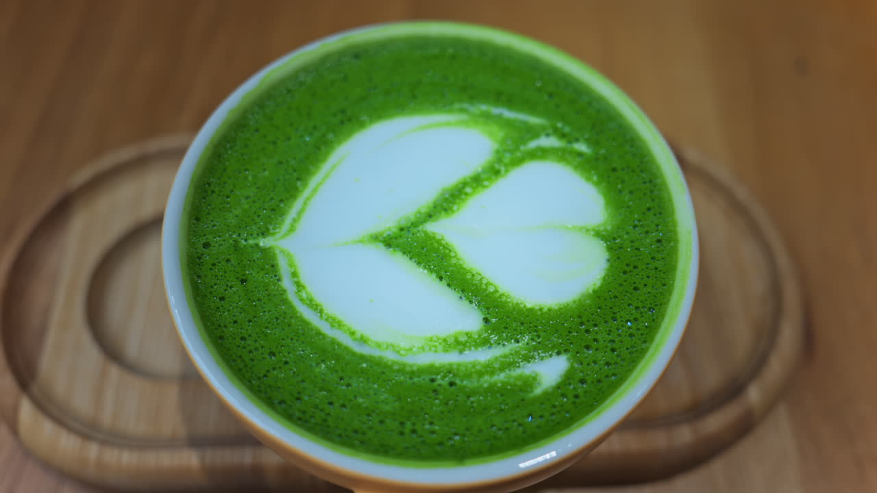 Close up of a matcha latte on a wooden tray at a cafe