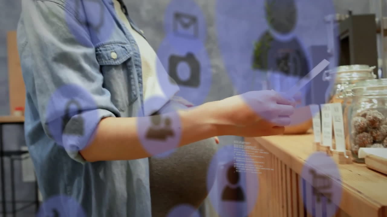 animación de iconos de medios y procesamiento de datos sobre feliz mujer asiática embarazada en el café