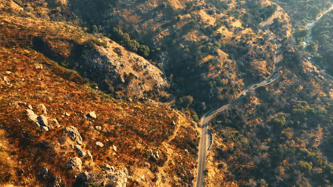 Slopes of mountains covered with poor plants. Drone footage above the highway in mountains of California.