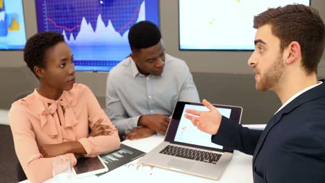male and female executives discussing over laptop 4k