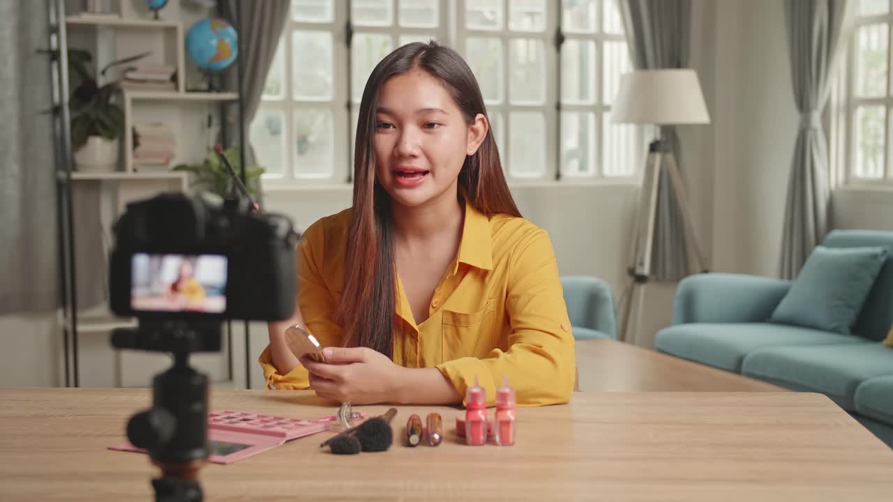 Asia Beauty Blogger Woman Filming Daily Make-Up Routine Tutorial At Camera On Tripod. Influencer Girl Live Streaming Cosmetics Product Review In Home Studio
