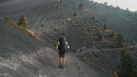 Back-View-Of-A-Man-Carrying-Backpack-Walking-On-The-Narrow-Trail-On-Hills-To-The-Crater-Of-Acatenango-Volcano