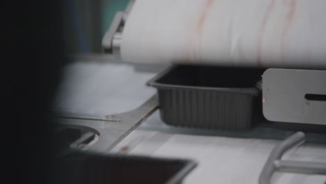 minced meat dropping in plastic boxes on a conveyor belt