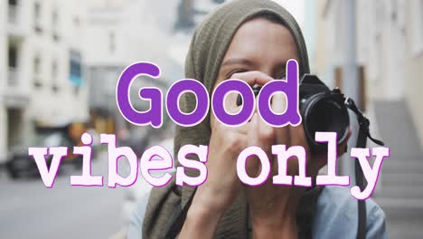 animation of text good vibes only over woman taking photo