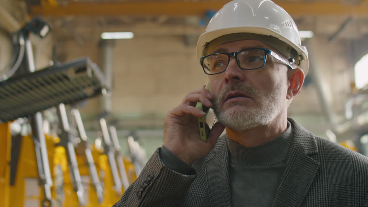 Senior Engineer Speaking on Phone in Factory