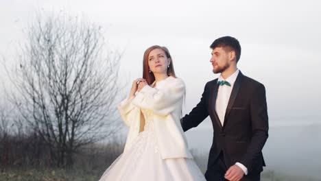 Newlyweds.-Caucasian-groom-with-bride-on-the-morning-field.-Fog.-Wedding-couple