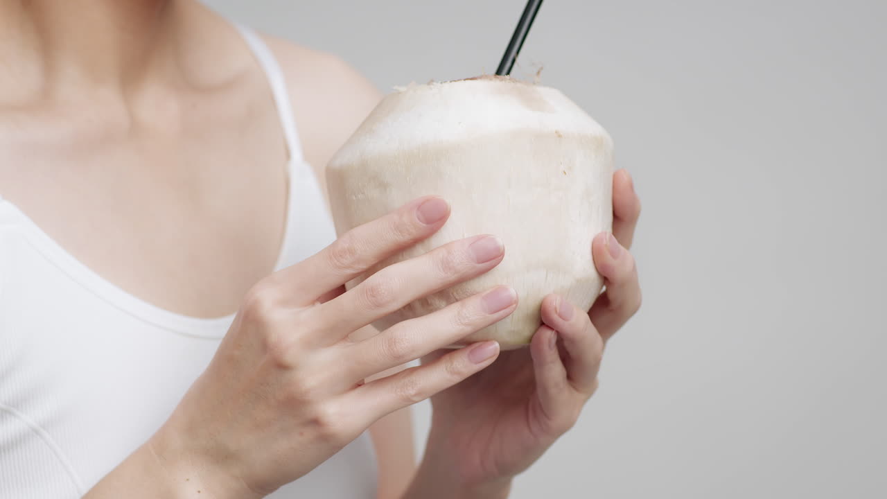 mujer bebiendo agua de coco