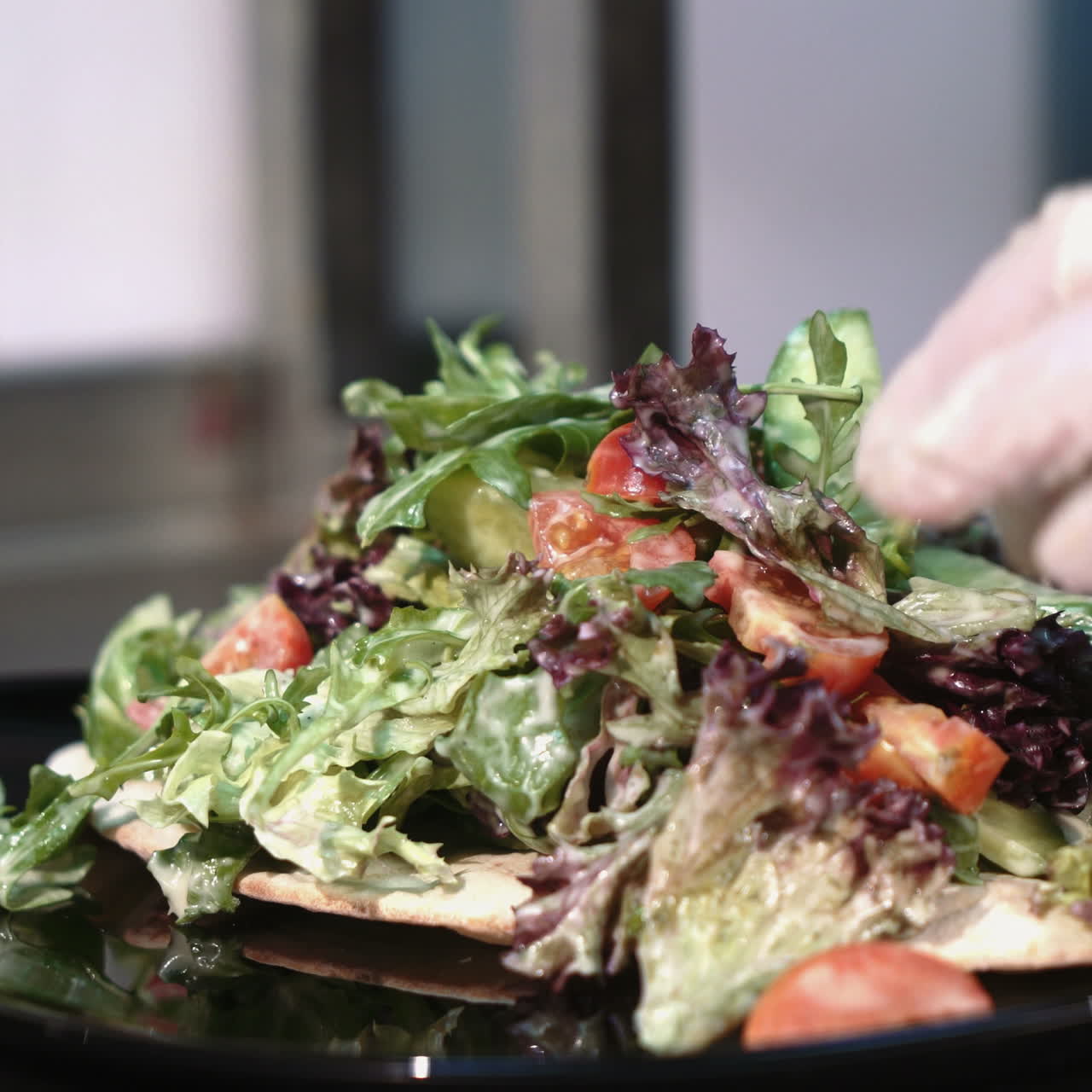 Professional chef in a commercial kitchen is garnishing and serving salad. Sqare video