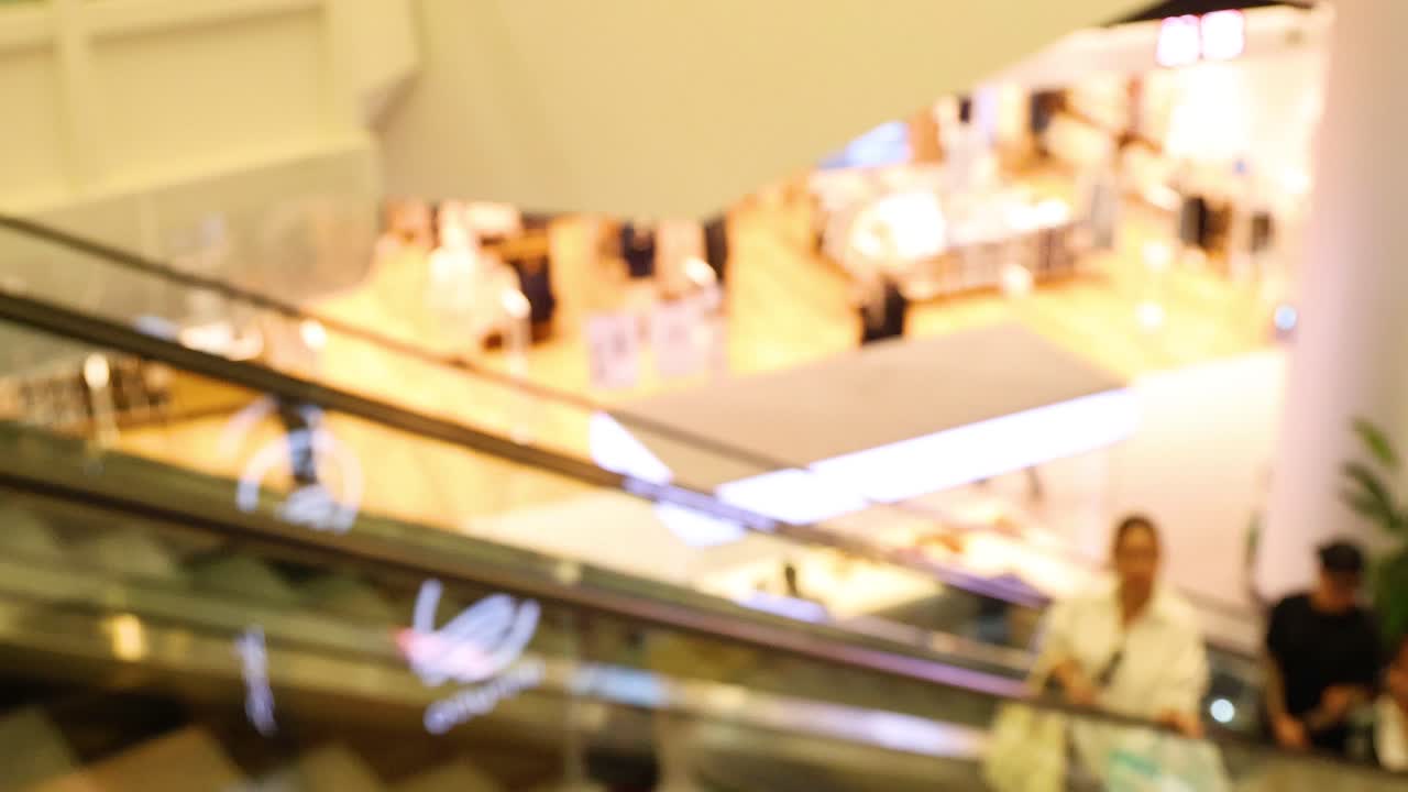 los compradores navegan por las escaleras mecánicas en el bullicioso centro comercial