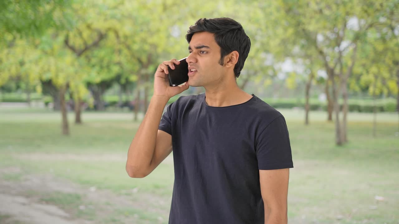 화난 인디언 남자가 누군가와 통화하고 있습니다.