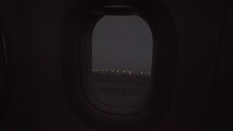 an evening rainy view from an airplane porthole
