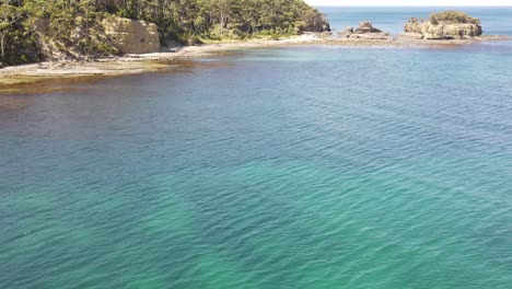 Drohnenschwenk-über-Tropisches-Blaues-Wasser,-Um-Berge-Und-Felsen-Zu-Zeigen