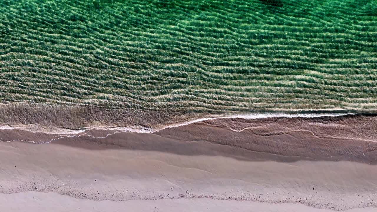 una playa pacífica con olas rompiendo en la arena y una ola verde del océano que viene de la orilla y una ola verde del océano que viene de la parte superior
