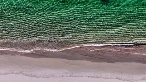 a peaceful beach with waves crashing on the sand and a green ocean wave coming in from the shore and a green ocean wave coming in from the top