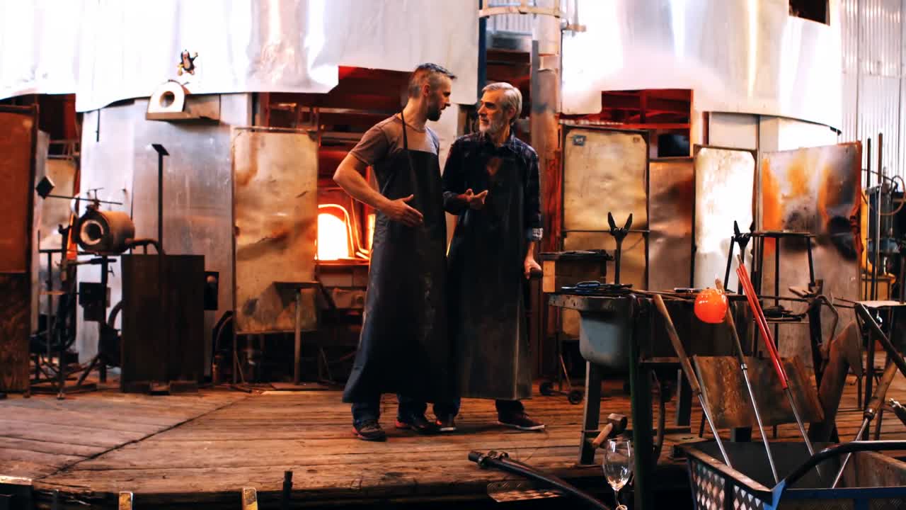 Glassblower interacting with colleague