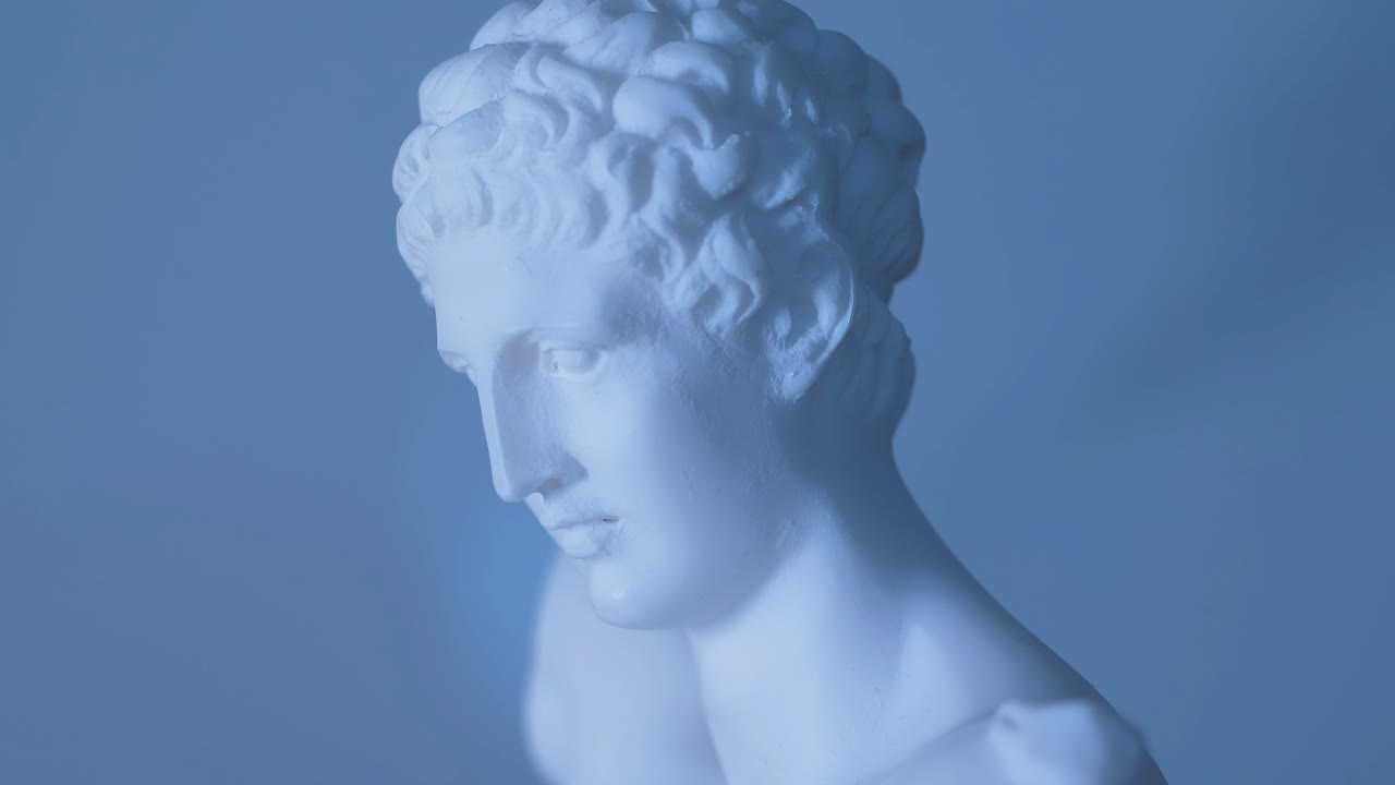 Statua rotante del dio greco Apollo in luce calda.