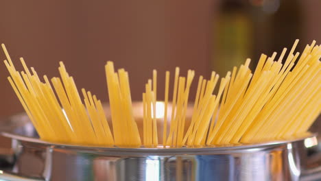 hand put spaghetti in a pan in slow motion