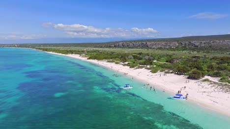 aerial view showing tourist with boat at bay of las aguilas in pedernales, beautiful landscape with blue water and and sandy beach