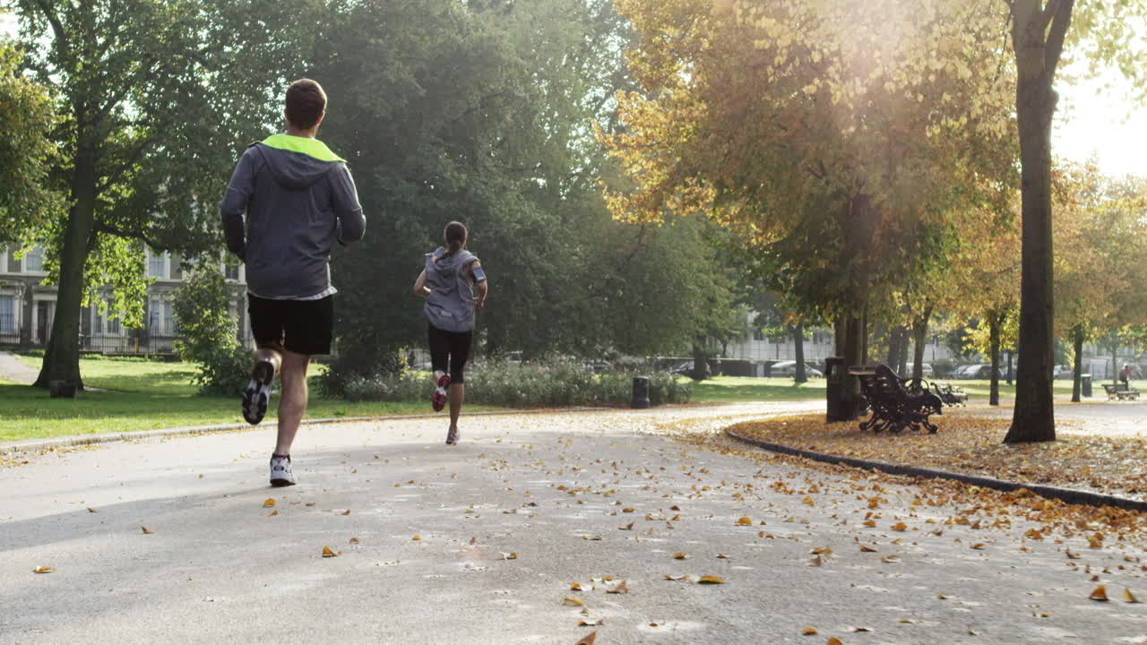 Group of runners running in park wearing wearable technology connected devices
