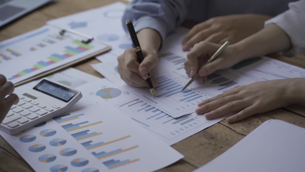 Close-up of a financial analyst and a planning team of young entrepreneurs discussing project ideas using papers to brainstorm modern business firms.