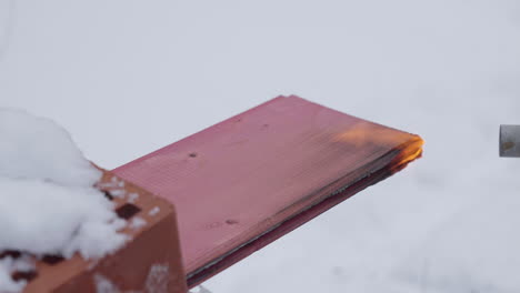 burning pink wood plank in the snow