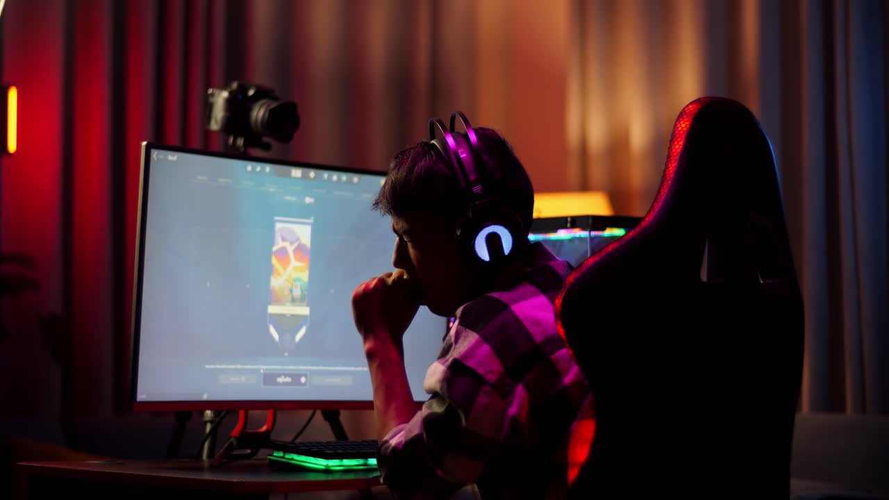 Back View Of Asian Boy Streamer Playing Game Over Network On Personal Computer. Yawning And Sleeping, Live Stream Video Game, Desk Illuminated By Rgb Led Strip Light