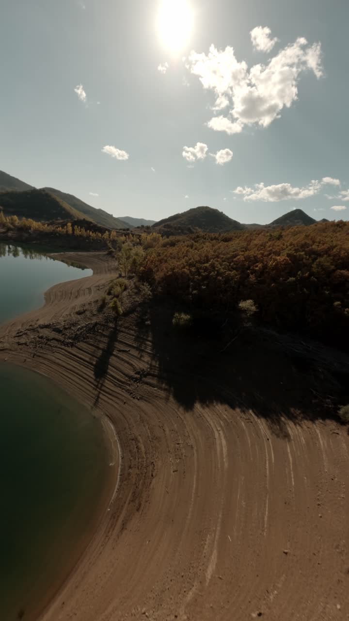 Riprese cinematografiche verticali con drone FPV che volano sopra le acque calme e la costa frastagliata del bacino di Porma a León, Spagna. Ideale per social media di viaggio e documentari sulla natura.