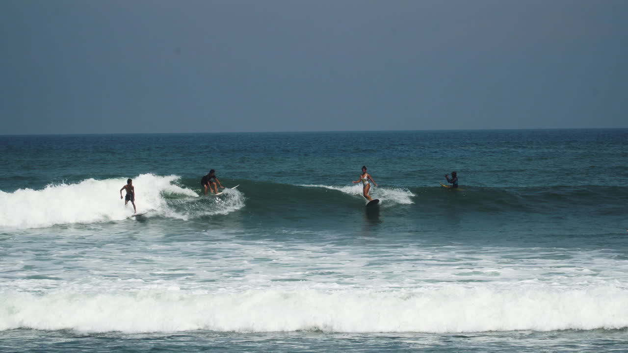escena de playa con surfistas surfeando olas en bali