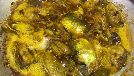 hilsha fish simmering in sauce in pot