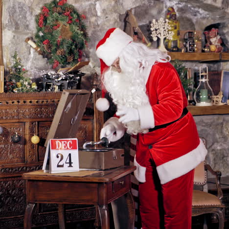 Santa Claus standing in specially decorated room, putting shellac or record on a gramophone or record player. Christmas spirit concept close up portrait. Christmas eve. New Year is coming