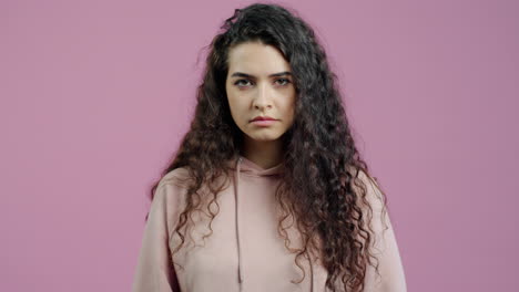 woman with curly hair wearing a pink hoodie
