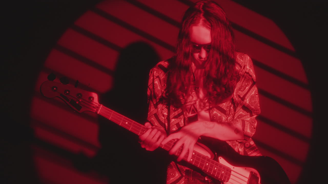 Indie Musician Playing the Guitar in Red Spotlight