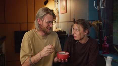 pareja de amor por la mañana: chico rubio y chica están volando desayuno por la mañana juntos. chico rubio y chica están volando desayuno por la mañana juntos. cereales con leche por la mañana en una habitación acogedora