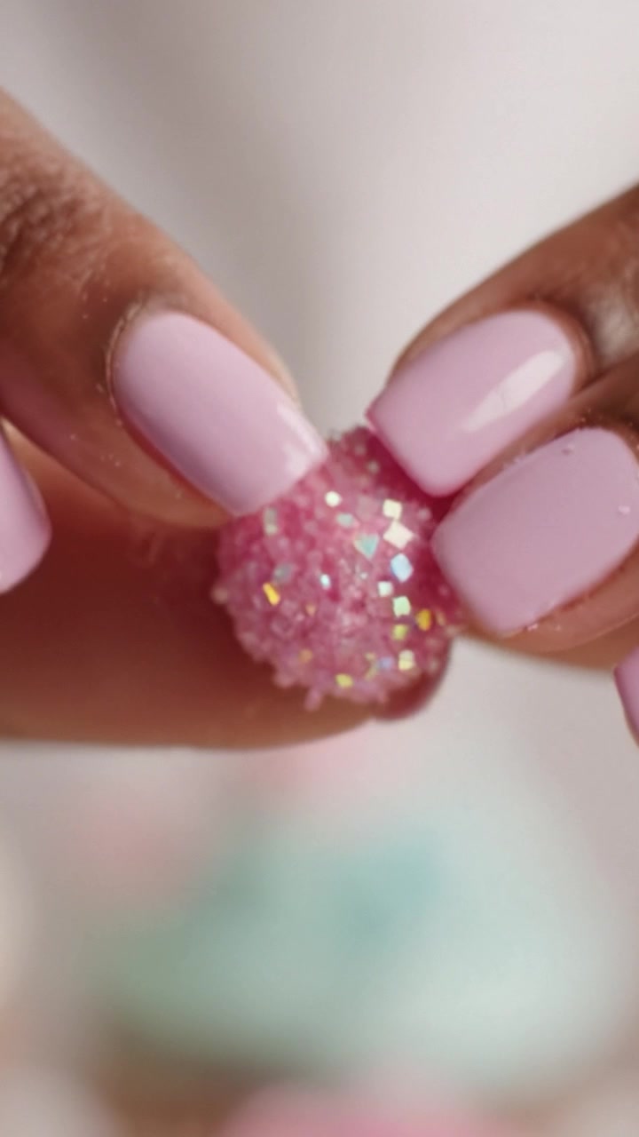 Um Close-Up de Mãos Delicadas Segurando um Doce Rosa Brilhante, Exibindo Nail Art Estilosa e Guloseimas Doces para uma Experiência de Sobremesa Divertida.